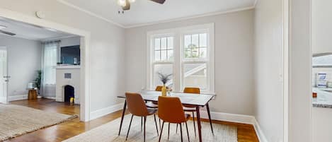 Un espace repas comprenant une table, des chaises et un ventilateur de plafond.