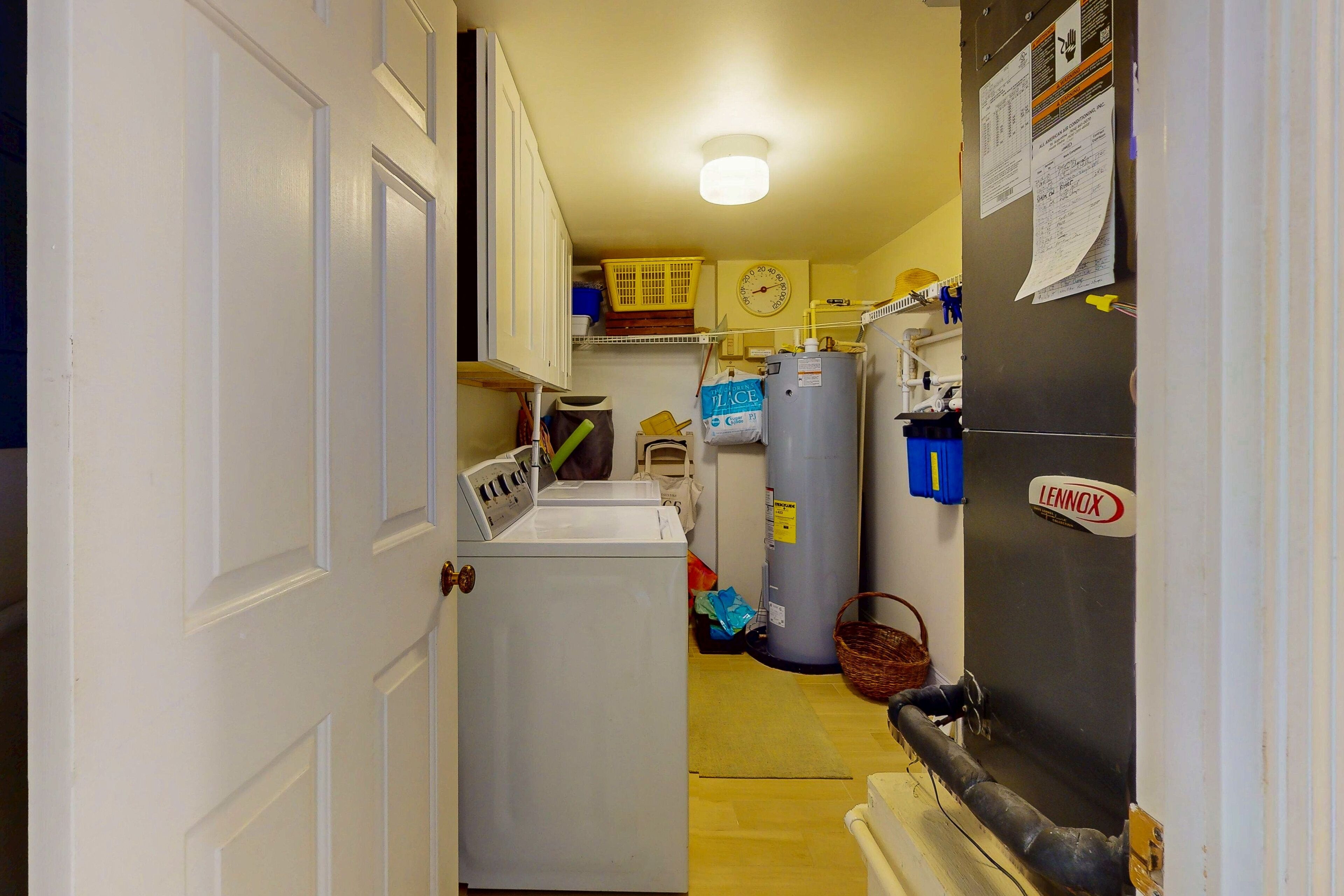 Una cocina estrecha con lavadora, refrigerador y calentador de agua.