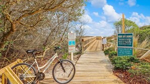 A wooden boardwalk leading to a beach with a bicycle parked on the side. - Relaxing Amelia Island Retreat 2br/2ba Condo in Amelia Island Plantation (Fernandina Beach)