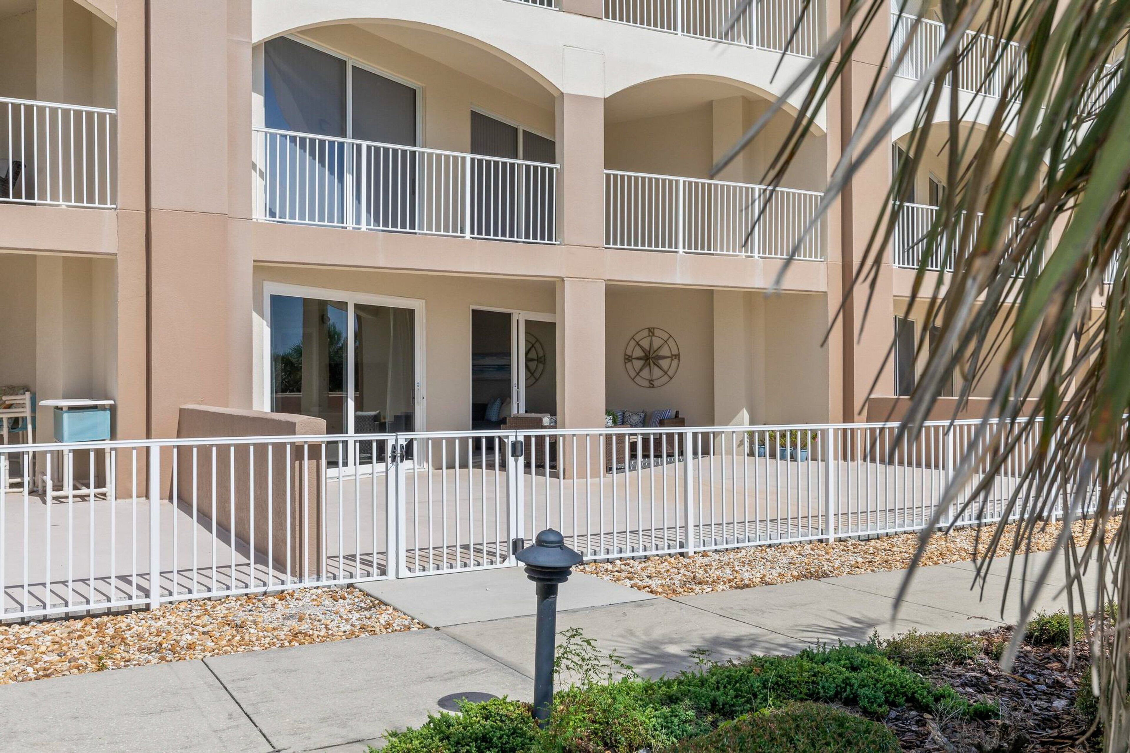 A multi-story hotel with balconies, a courtyard, and a palm tree.