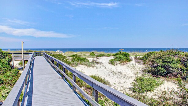 A wooden boardwalk leading to a beach with dunes and vegetation. - Oceanfront Condo With Pool & Tennis - Balcony, AC, Wifi & Washer/dryer (Fernandina Beach)