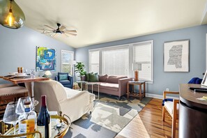 A modern living room with a sofa, coffee table, and dining area.