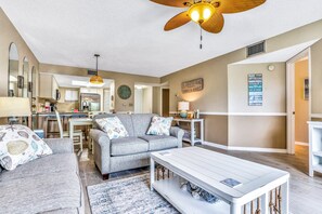 A living room with a grey sofa, a white coffee table, and a ceiling fan. - Third Floor Condo With Shared Pool, Free Wifi, Central AC, & Shared Tennis (St. Augustine)