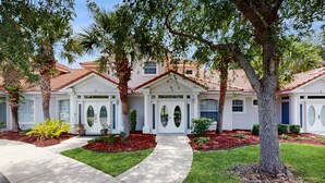 A residential property with a well-maintained lawn, a curved driveway, and a front entrance with a double door. - Spacious Townhouse With Private Balcony, Waterview, Pool and Wifi (Palm Coast)