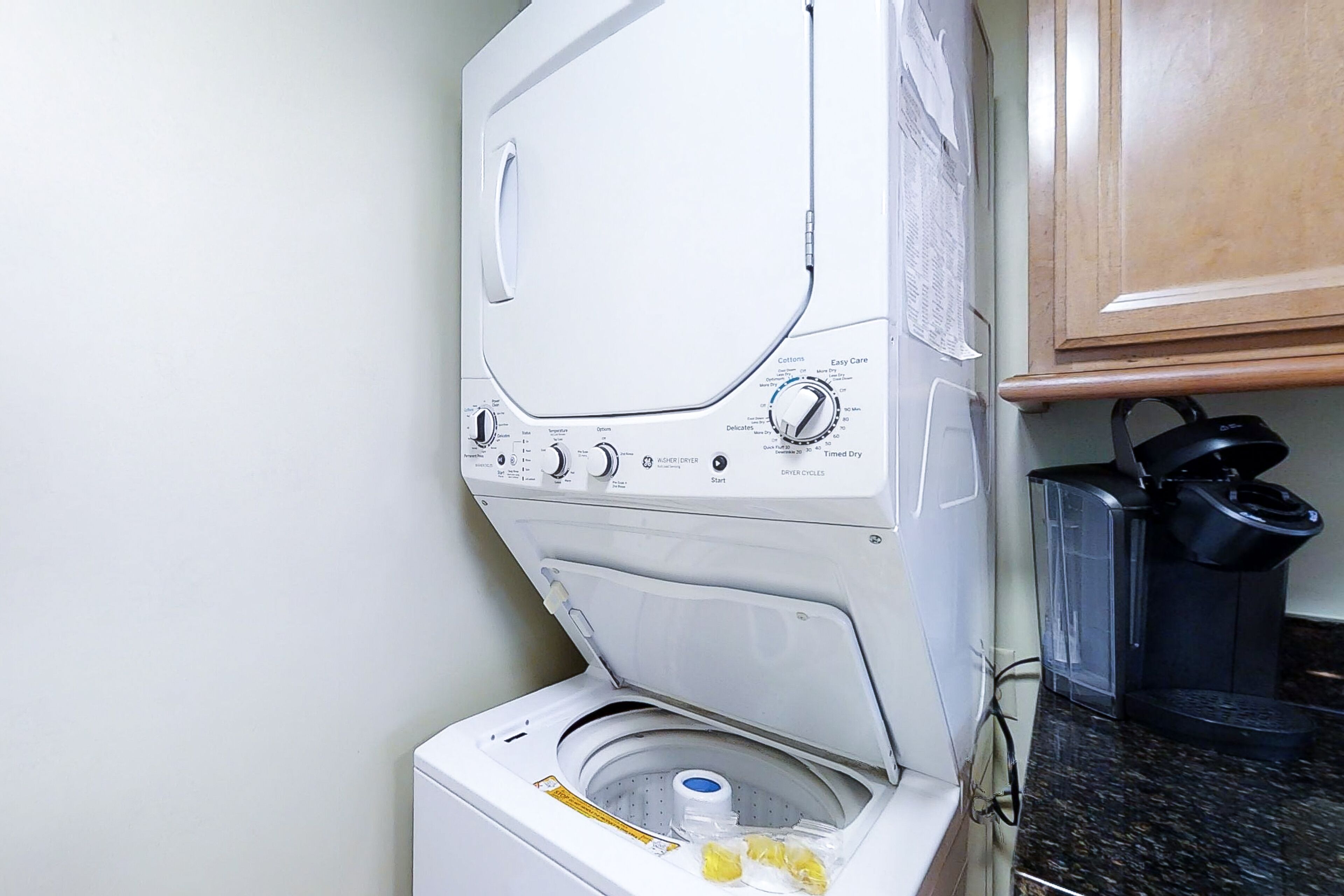 Een wasmachine met voorlader, voorzien van een bedieningspaneel, een zeepbakje en een waterpeilaanduiding.