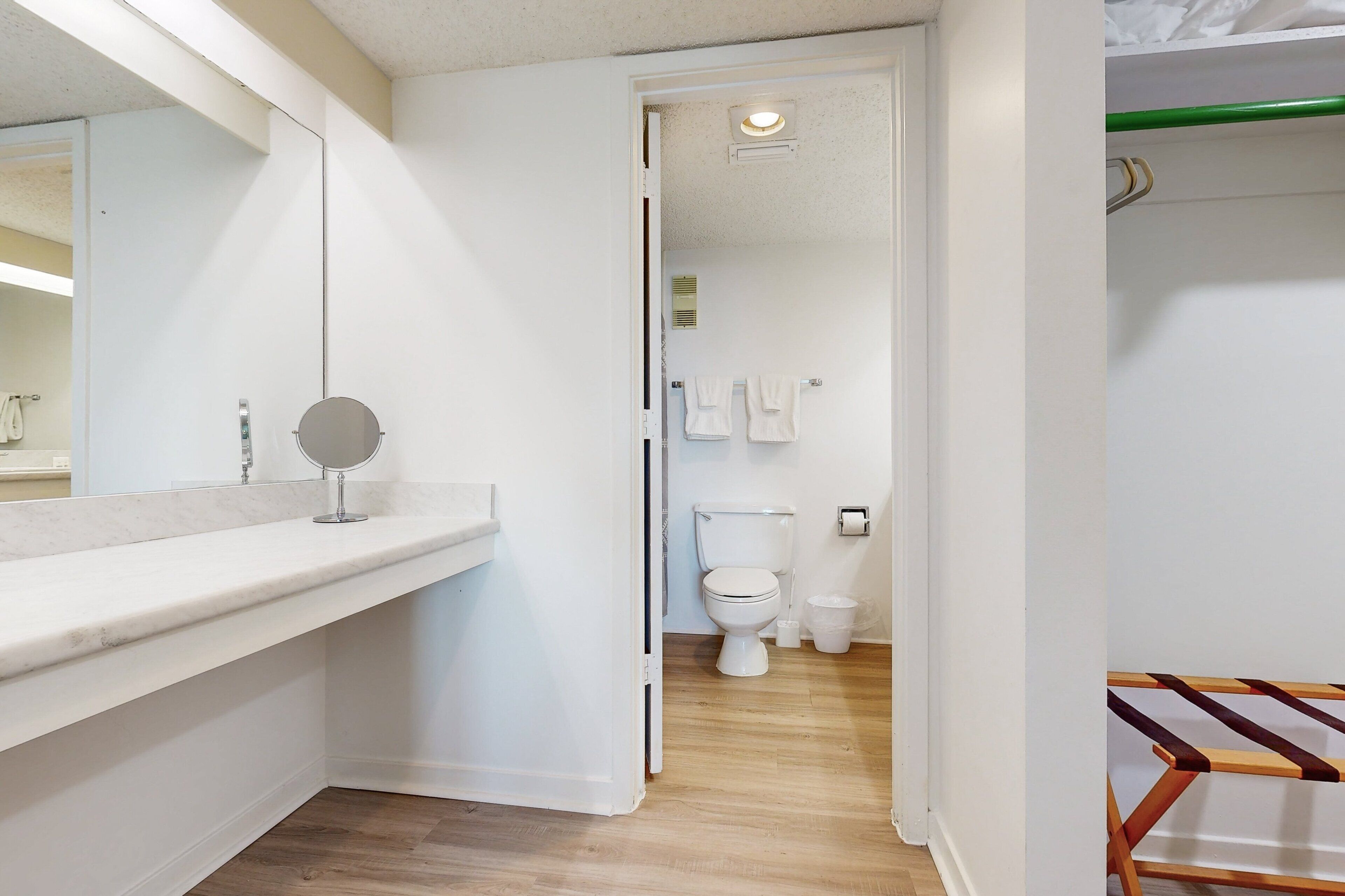 A modern bathroom with a white sink, mirror, and toilet.