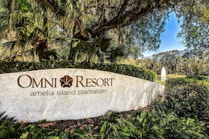 A sign for Omni Resort Amelia Island Plantation surrounded by lush greenery and a fountain. - Waterfront Condo With Balcony, Views, Pool & Tennis (Fernandina Beach)
