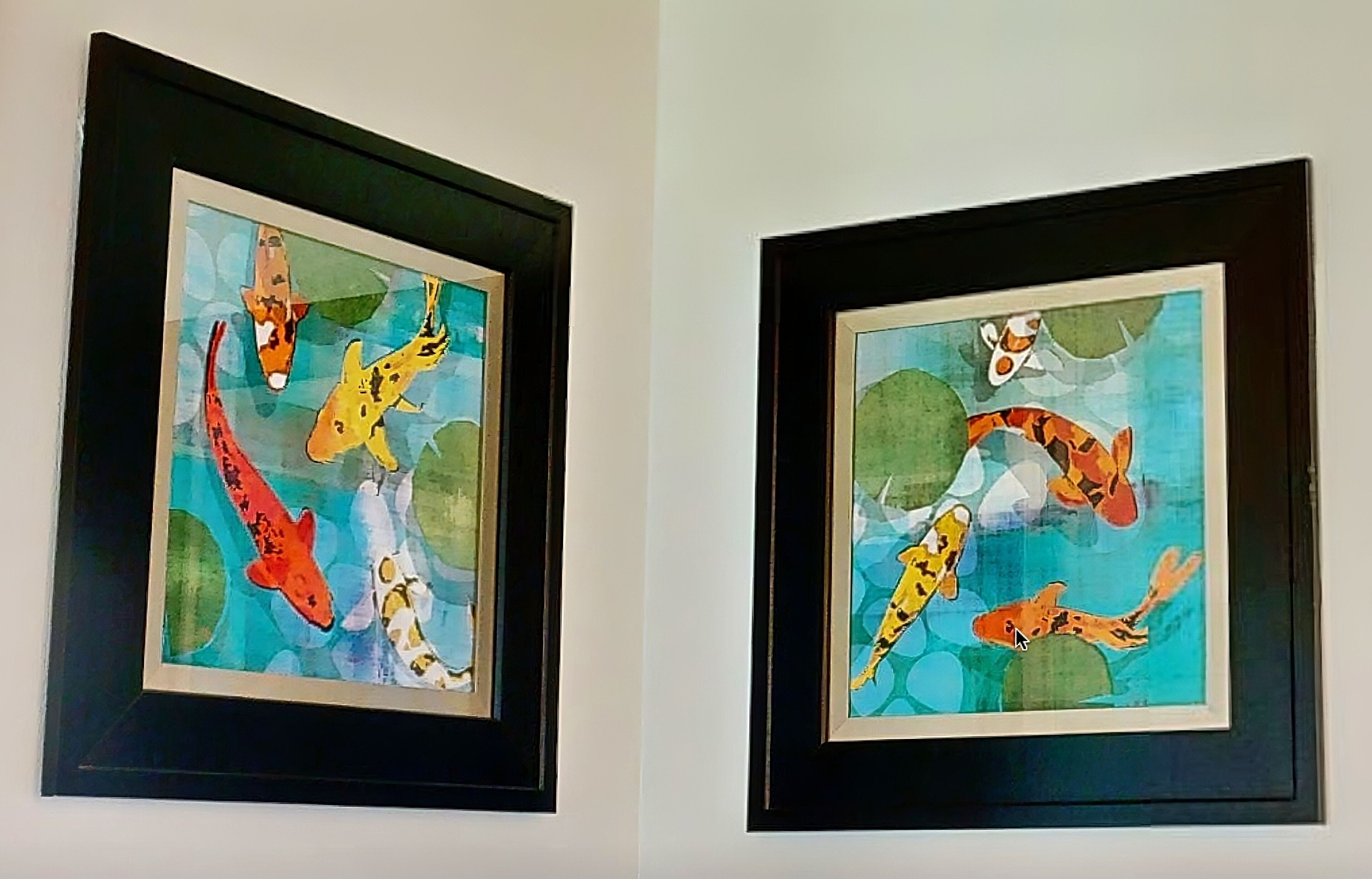 Deux tableaux encadrés représentant des carpes koï, accrochés à un mur.