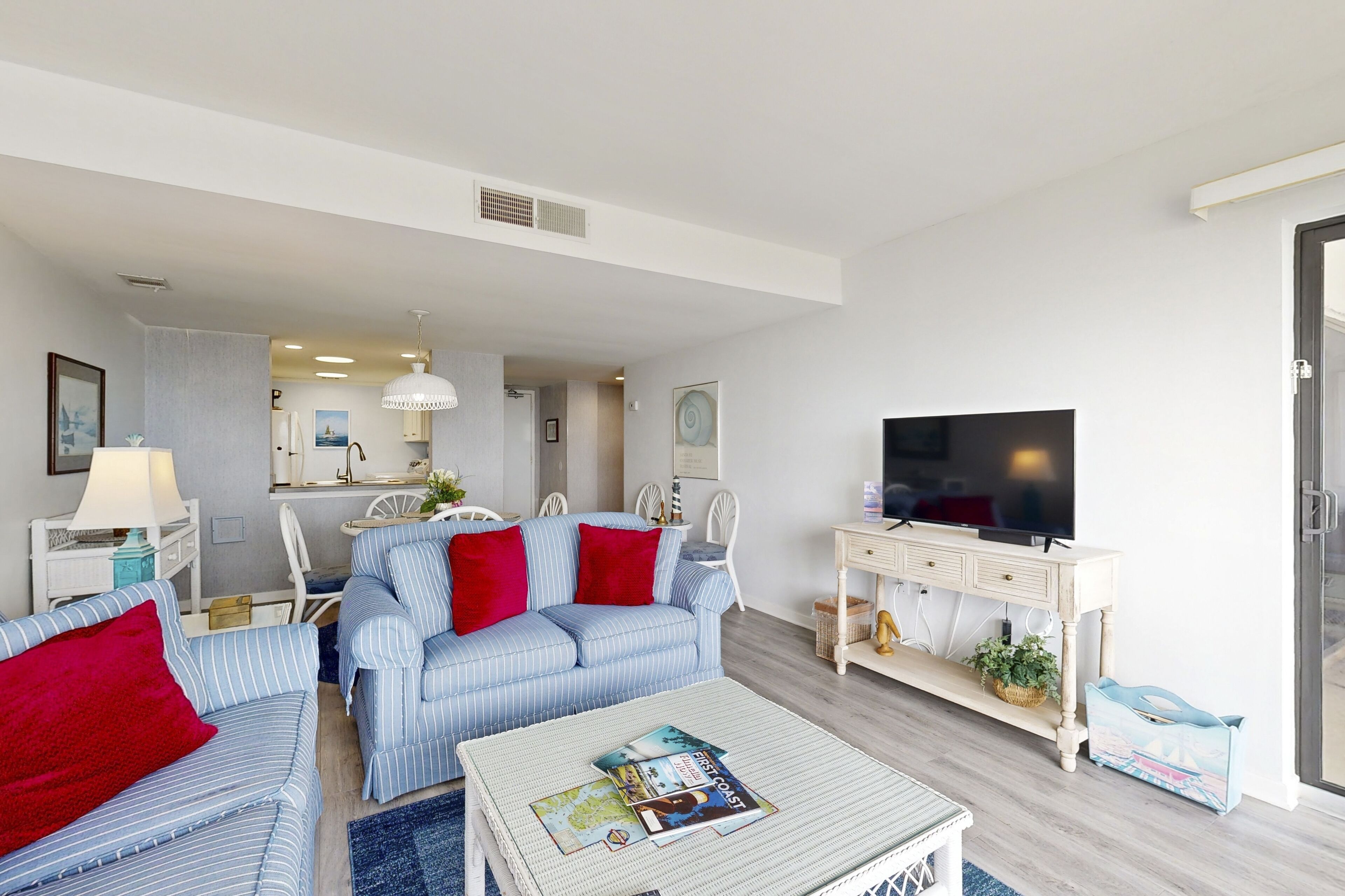 A modern living room with a sofa, armchairs, a coffee table, and a television.