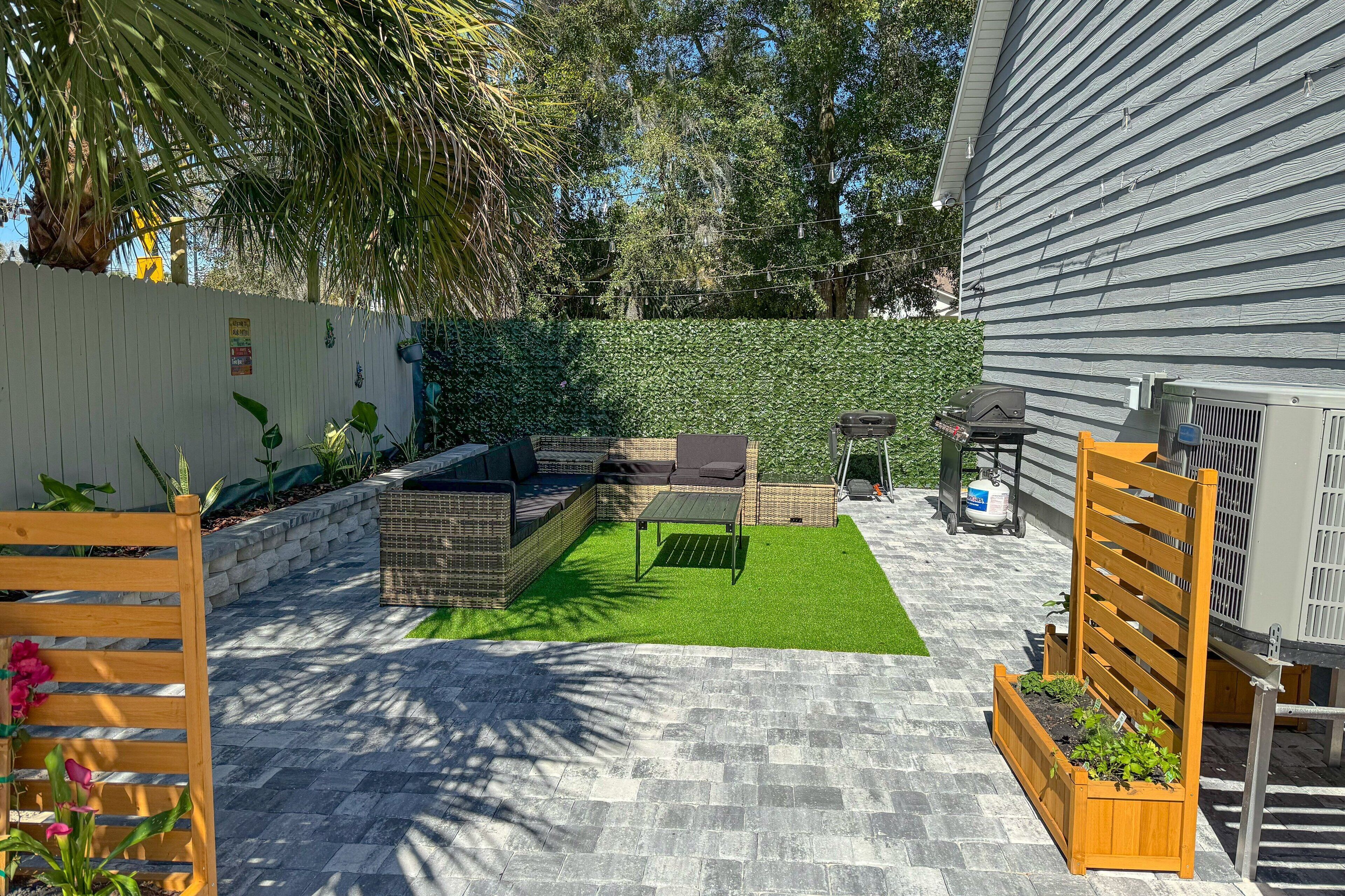Un'area patio con un angolo salotto, un tavolino e fioriere.