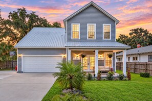 A two-story house with a garage, a covered porch, and a well-maintained lawn. - Updated, Dog-friendly gem W/fenced Yard, Foosball & Pool Tables, Wifi, Fireplace (St. Augustine)