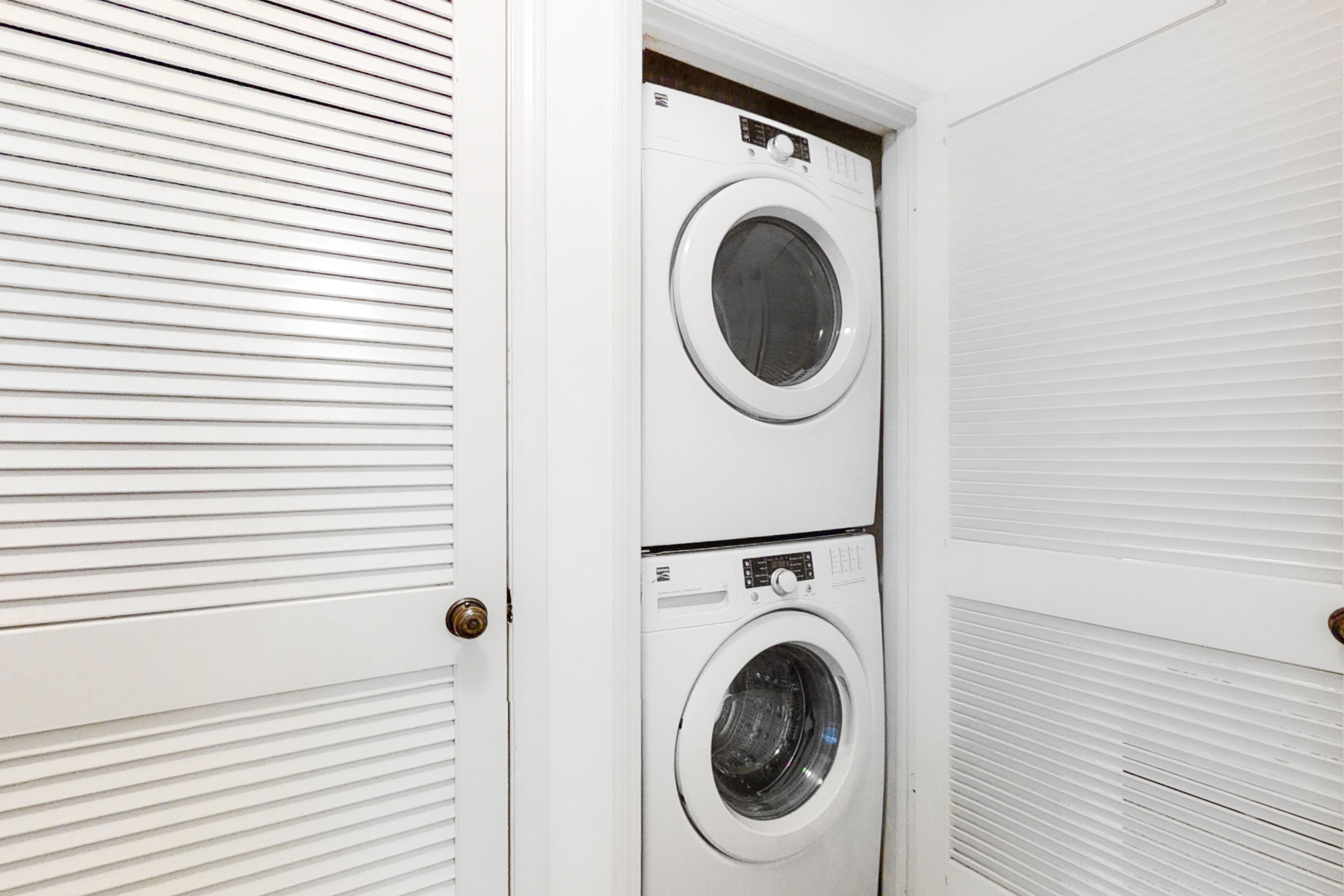 A laundry room with two stacked front-loading washing machines.