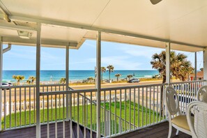 A covered balcony with a view of the beach and ocean. - Updated Home Across From Beach With Covered Balcony, Central AC, & Washer/dryer (Flagler Beach)