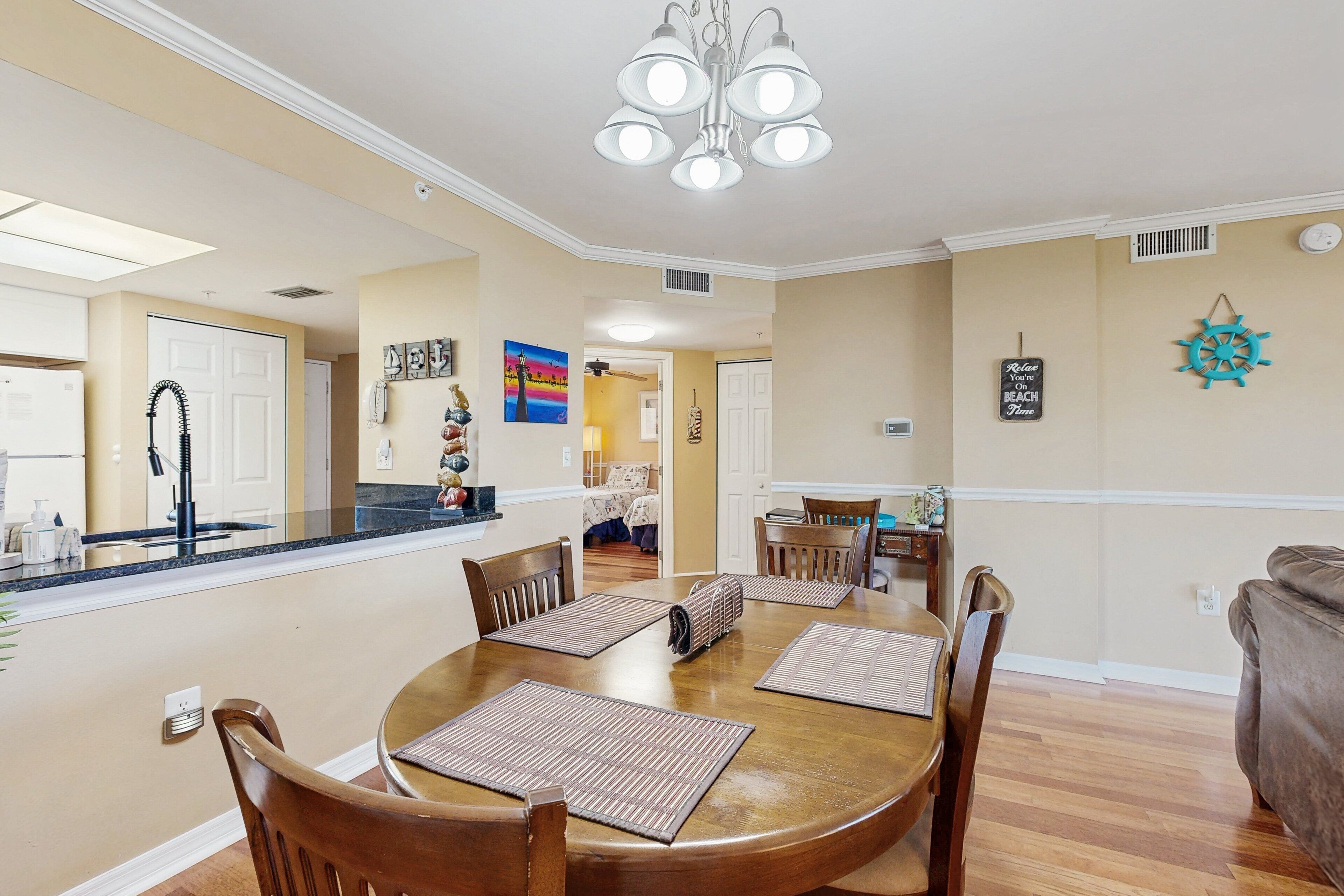 A dining area with a round table, chairs, and a chandelier.