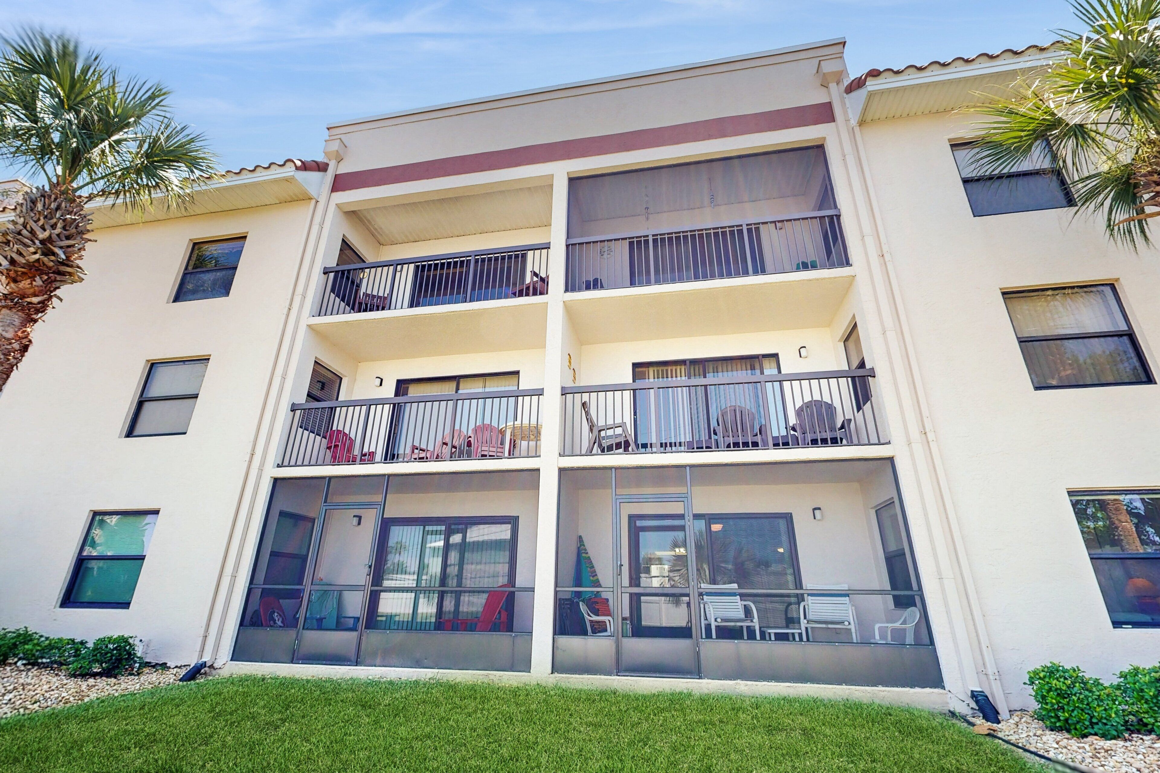 A multi-story building with balconies, large windows, and a flat roof.
