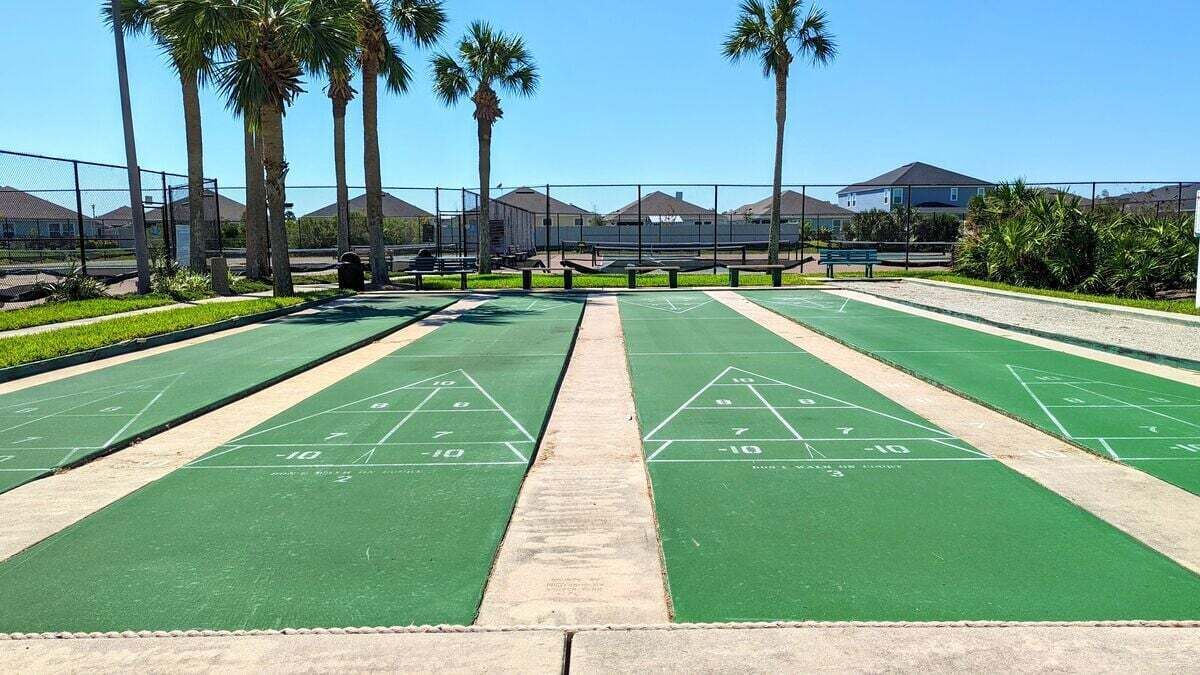 A shuffleboard court with green playing surfaces and numbered scoring areas.