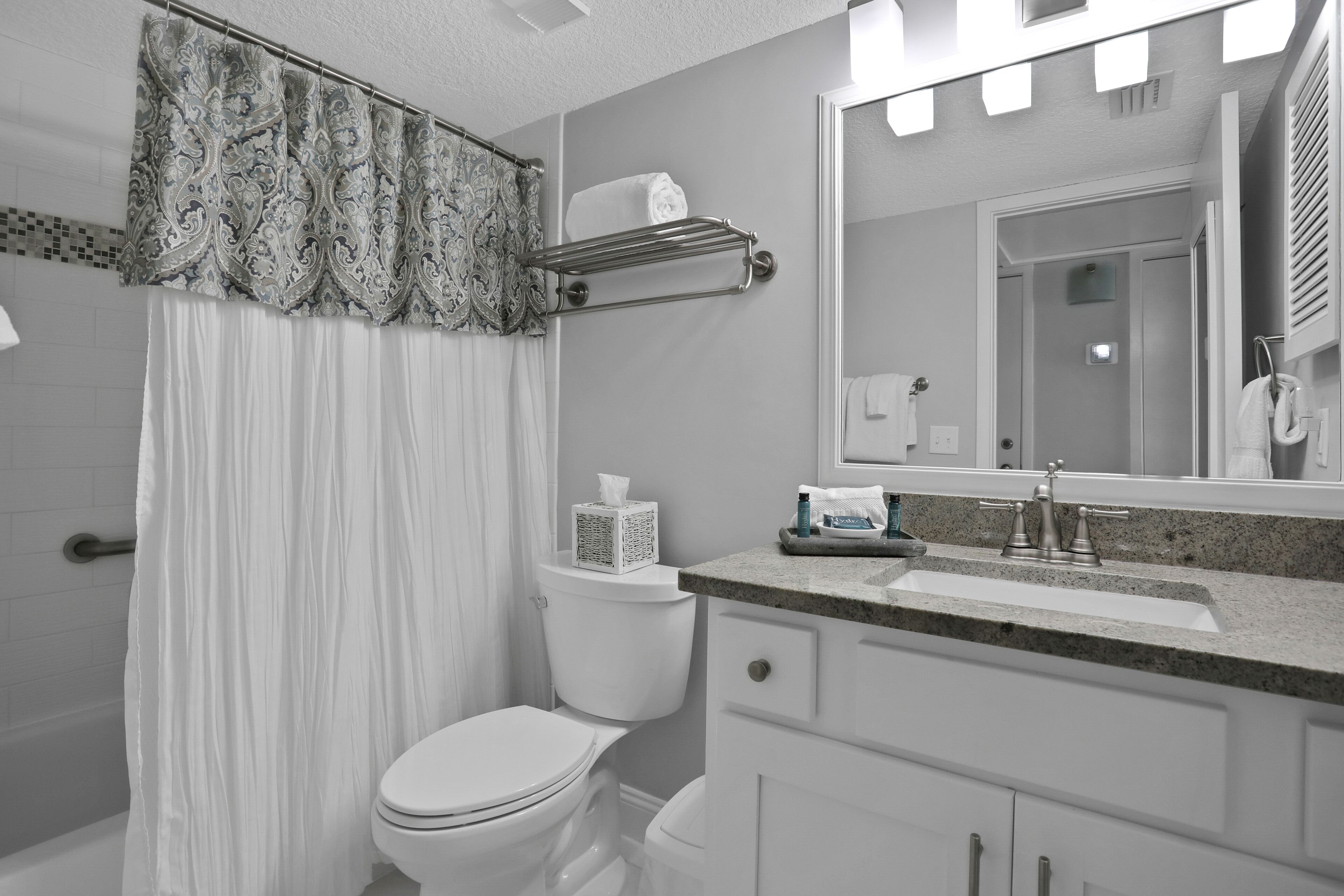 A modern bathroom with a toilet, sink, and mirror.