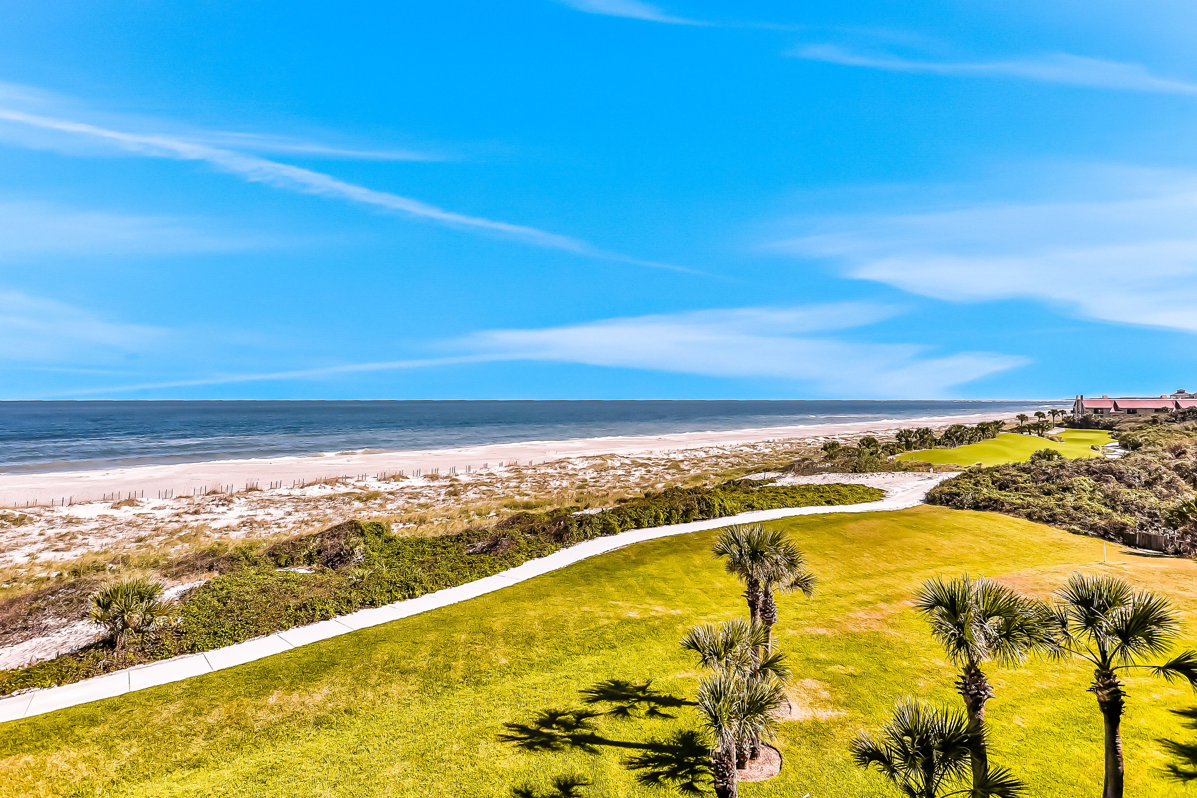 Un parcours de golf avec une plage de sable et une vue sur l’océan.