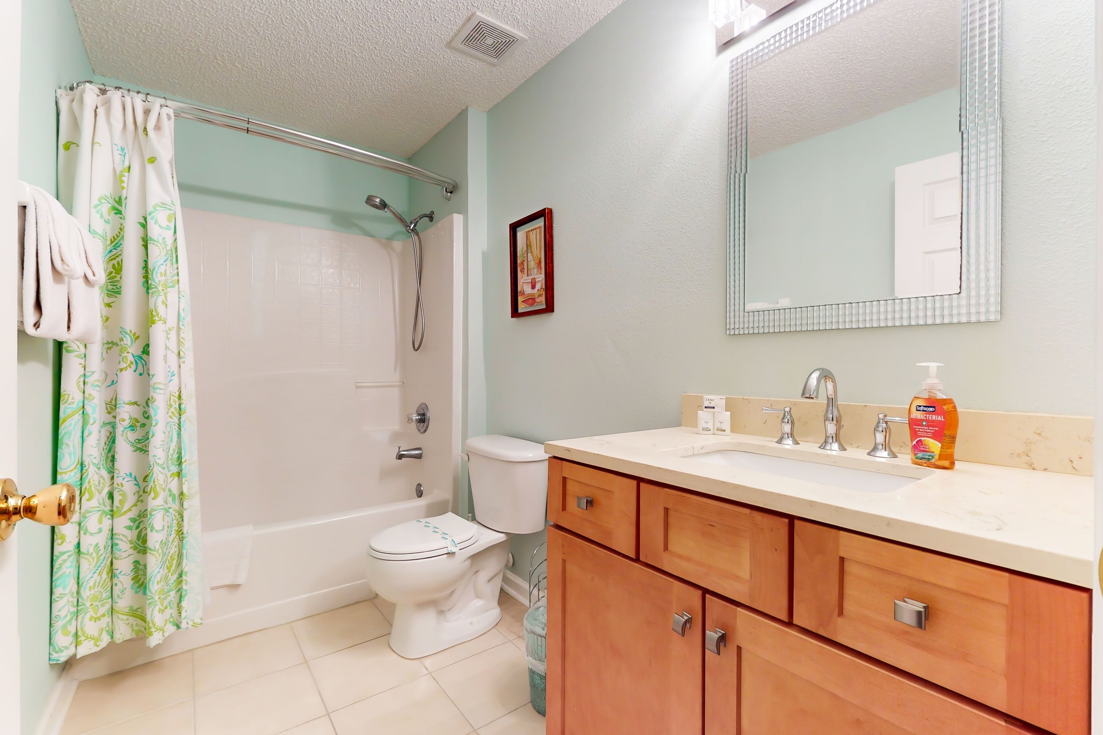 A bathroom with a shower, toilet, and sink.