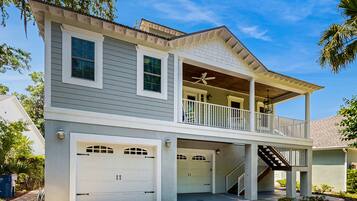 A two-story house with a covered porch, a balcony, and two attached garages.