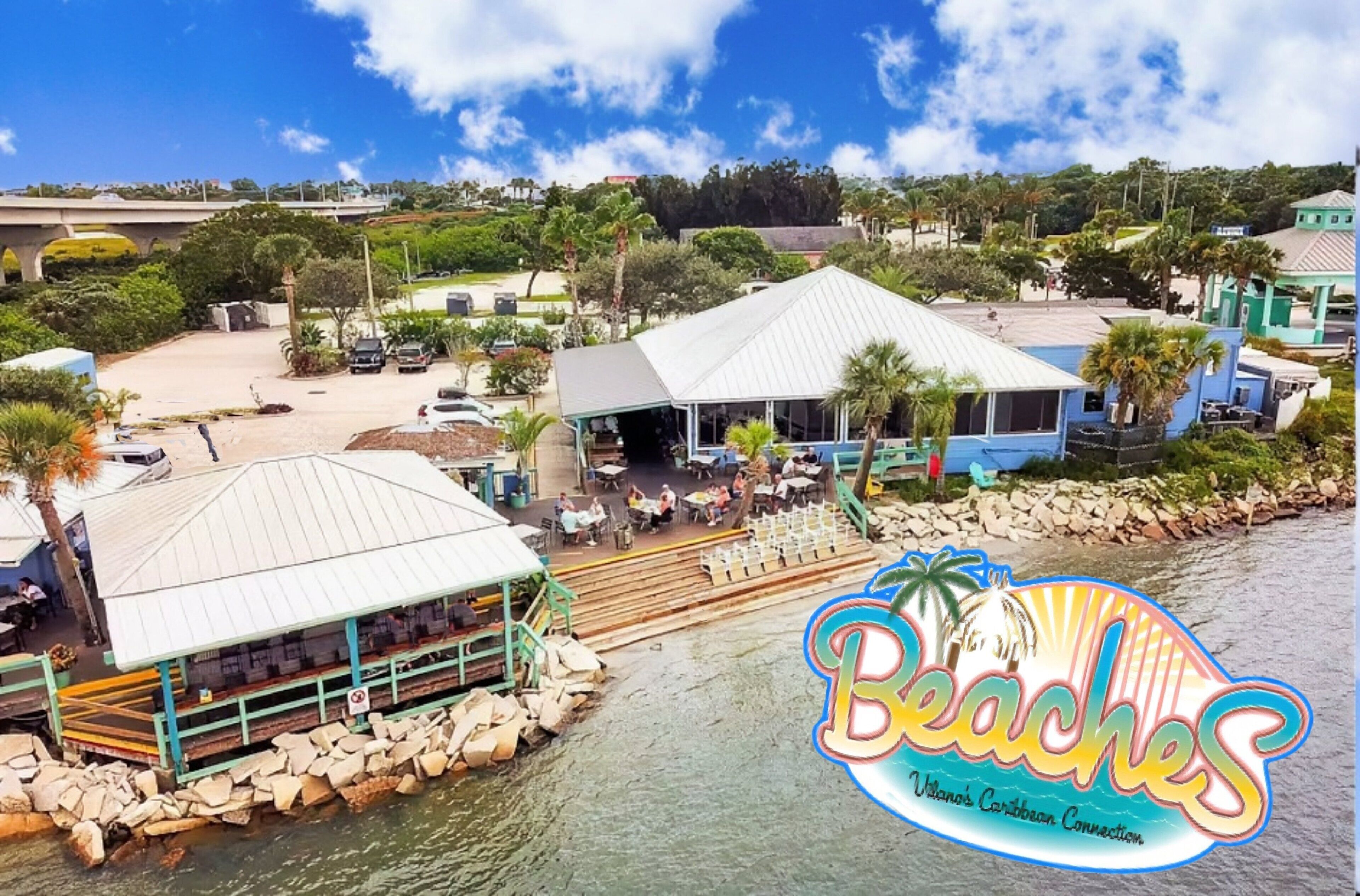A beachfront property with a dining area, a covered outdoor seating area, and a view of the water.
