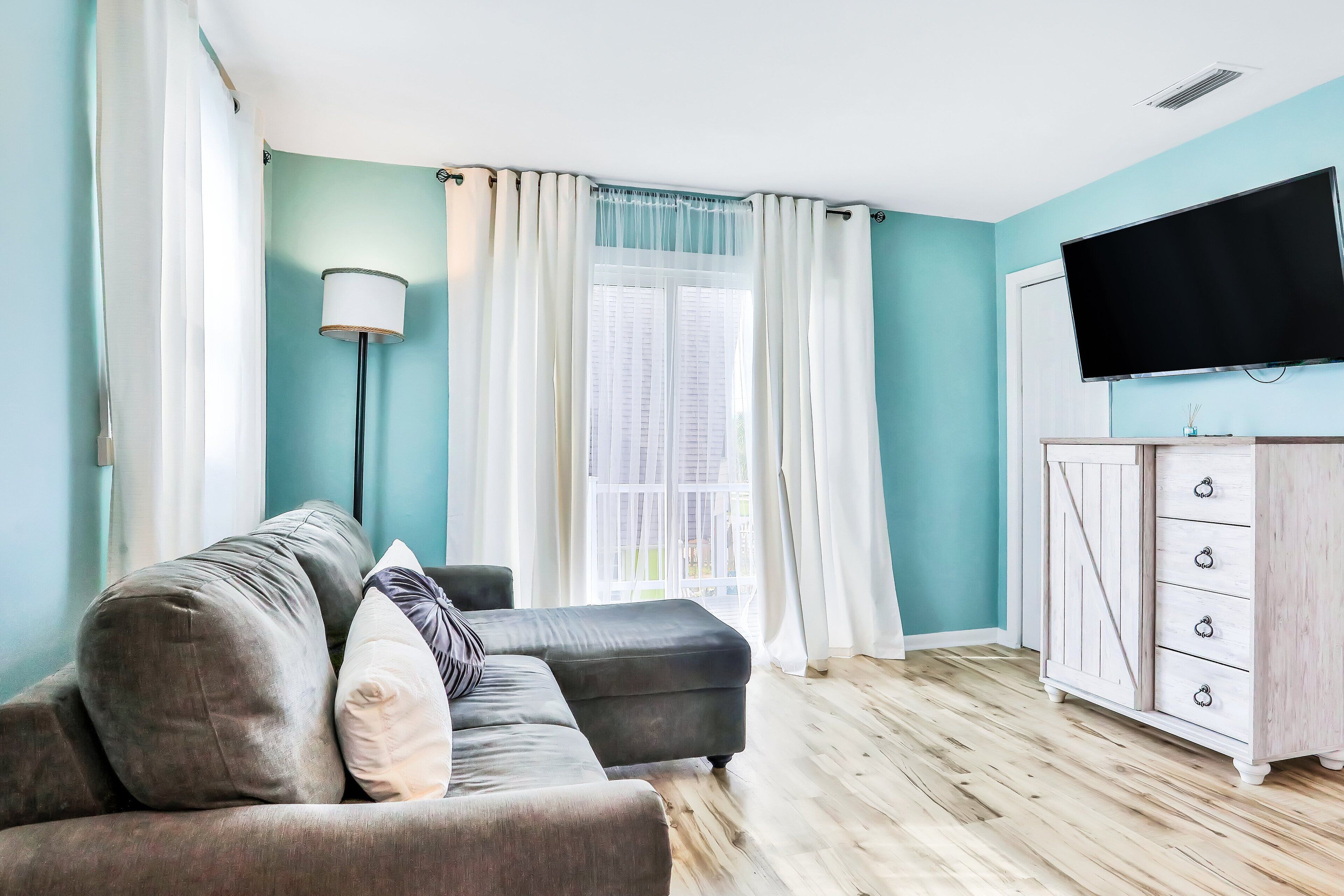 A living room with a sofa, a TV, and a wooden cabinet.