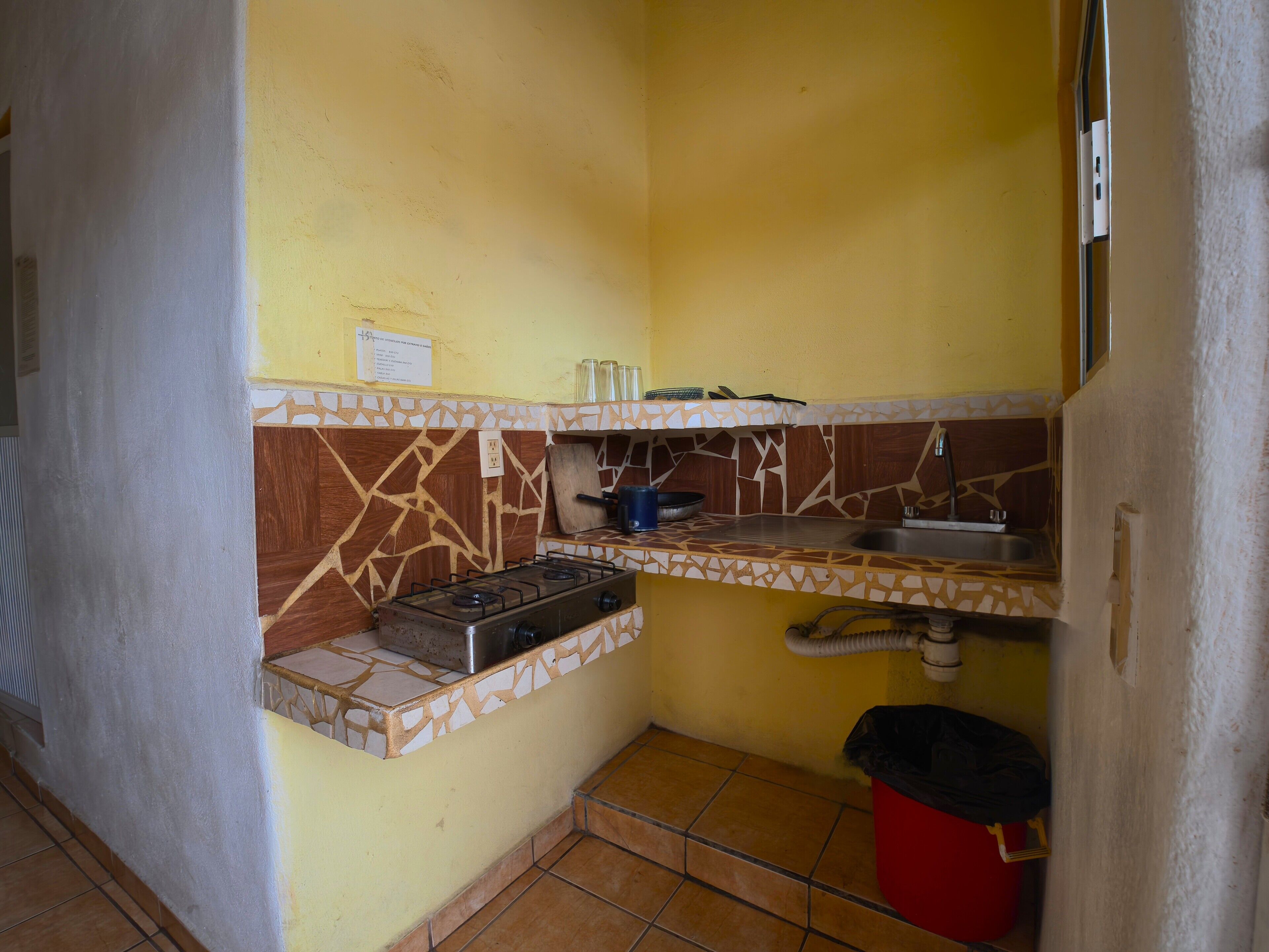 A compact kitchen with a gas stove, a sink, and a small countertop.