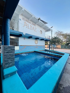 Un bâtiment doté d’une piscine, d’un balcon et d’une enseigne sur laquelle on peut lire « BUNGALONG ALDOZ ».