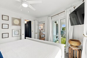 A bedroom with a bed, a ceiling fan, a window with curtains, and a view of the outdoors. - Steps to the beach! Perfect Location Seagrove area.  3BR 2 bath, 2Pool, sleeps 8 (Santa Rosa Beach)