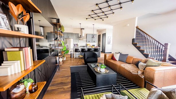 Ein modernes Wohnzimmer mit Sofa, Couchtisch und Bücherregalen.