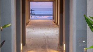 A hallway leading to a beach view with a logo 'CASA CHULA' on the wall.