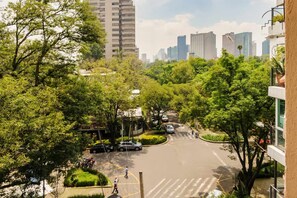 A tree-lined urban street with buildings in the background. - Magnifico Departamento Enfrente al Parque Lincoln! (Mexico City)