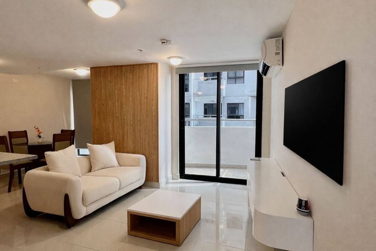 A modern living room with a sofa, coffee table, and TV.