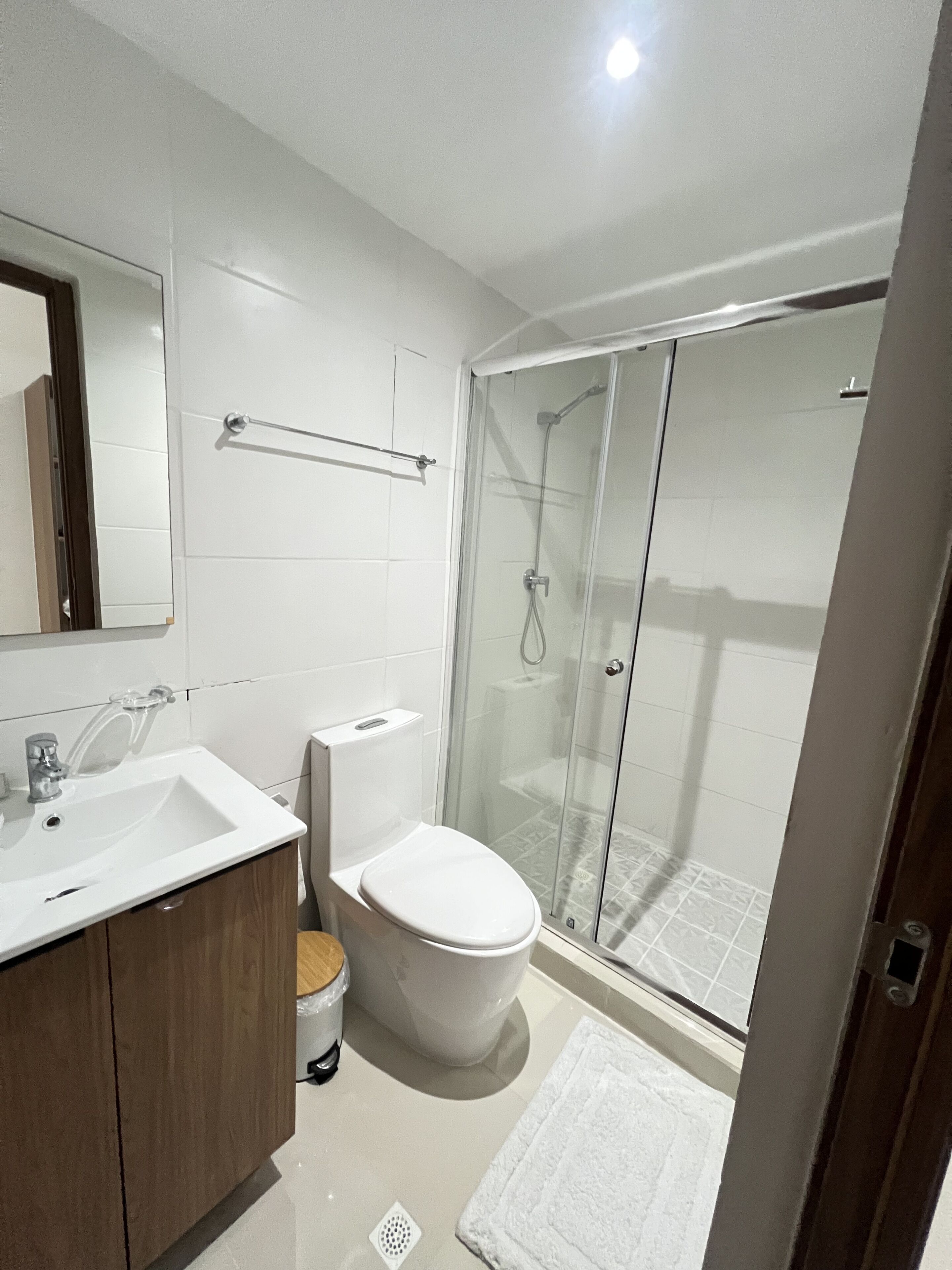 Une salle de bain moderne avec un lavabo, des toilettes et une douche à parois de verre.