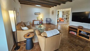A living room with a sofa, armchairs, a coffee table, and a TV stand. - Quintessential Tucson - 2BR/2BA Entire House - Lower Foothills (Tucson)