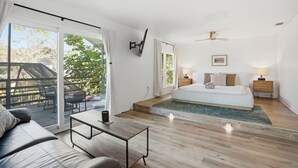 A bedroom with a bed, bedside tables, a ceiling fan, and a view of the outdoors. - Tampa Oasis: Pool & Hot Tub Retreat for Families (Tampa)