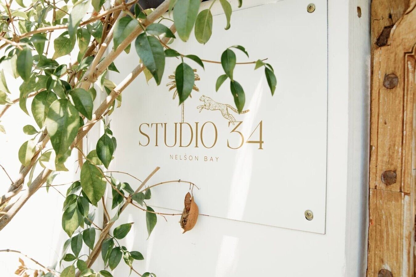 A sign with the text 'STUDIO 34' and 'NELSON BAY' indicating a hotel or accommodation.