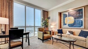 A hotel room with a large window, a dining area, a sofa, and a coffee table. - MGM Signature 34-818 Jacuzzi Studio UpperPenthouse (Las Vegas)