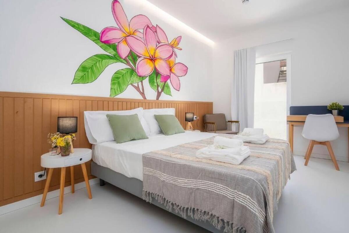 A bedroom with a bed, bedside tables, a desk, and a chair.