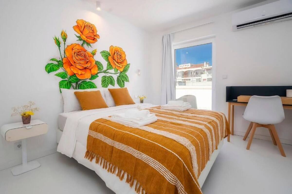 A modern hotel room with a large bed, a desk, and a window with a city view.