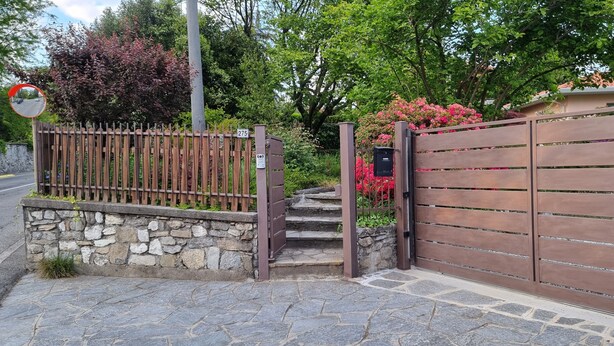 A stone wall, a wooden gate, and a mailbox.