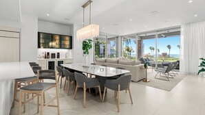 Una cucina moderna con zona pranzo, ampie finestre e vista sull'esterno.
