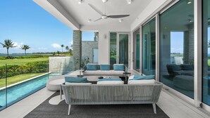 A modern outdoor living area with a pool, a sofa set, and a ceiling fan. - Exclusive 4 Bedroom Four Seasons Resort, Private Pool & Hot Tub, Steps to Beach (Rio Grande)