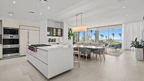 Una cucina moderna con isola centrale, elettrodomestici integrati e zona pranzo con vista.