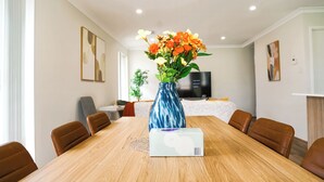 Una sala de conferències amb taula de fusta, cadires marrons, un ram de flors i una caixa sobre la taula.