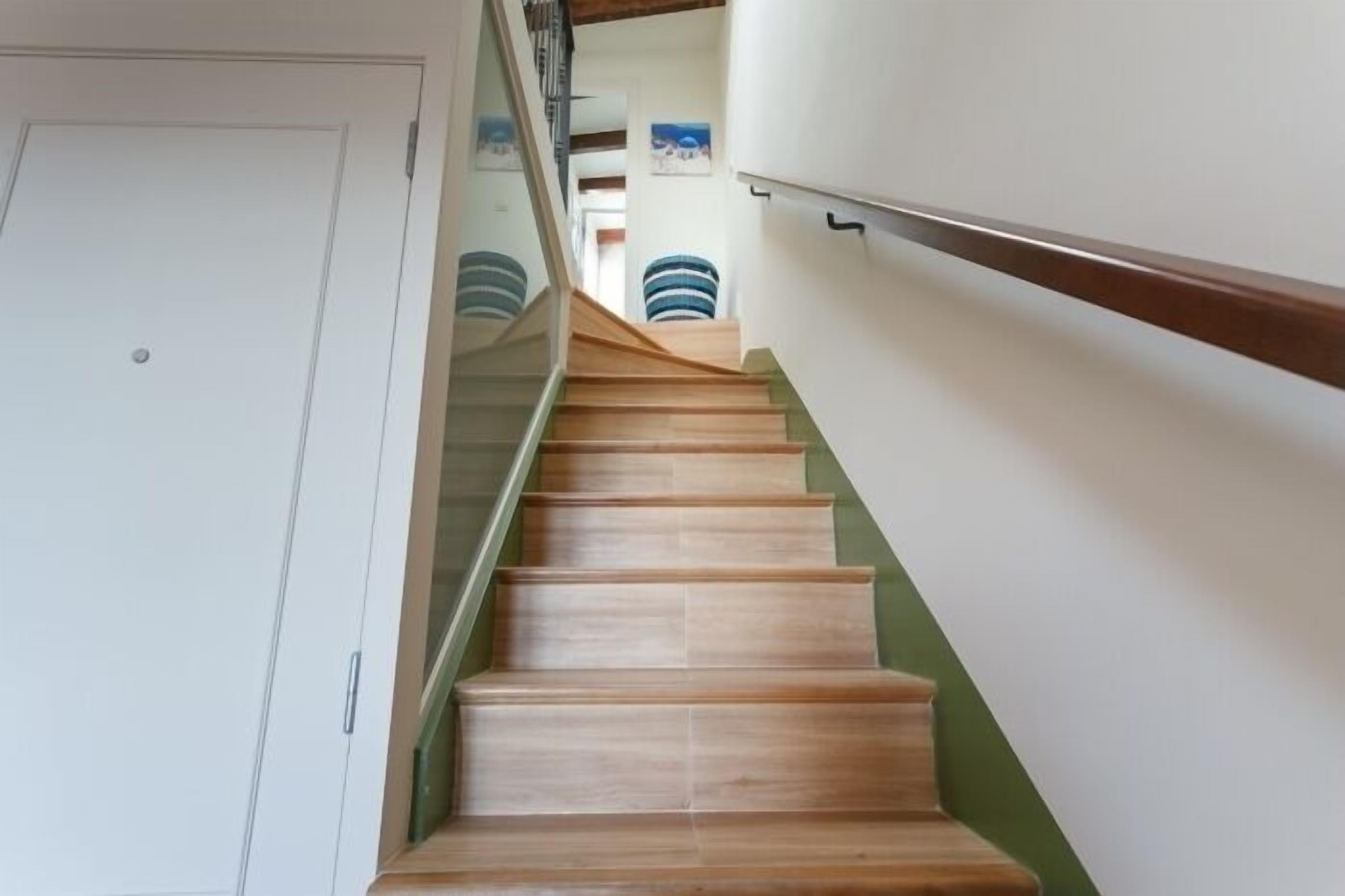 A staircase with wooden steps and a glass railing.