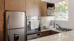 Eine moderne Küche mit einem Edelstahl-Kühlschrank, einem eingebauten Backofen und einem Gasherd.