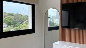Una habitación con un ventanal grande, un espejo y un televisor de pantalla plana.