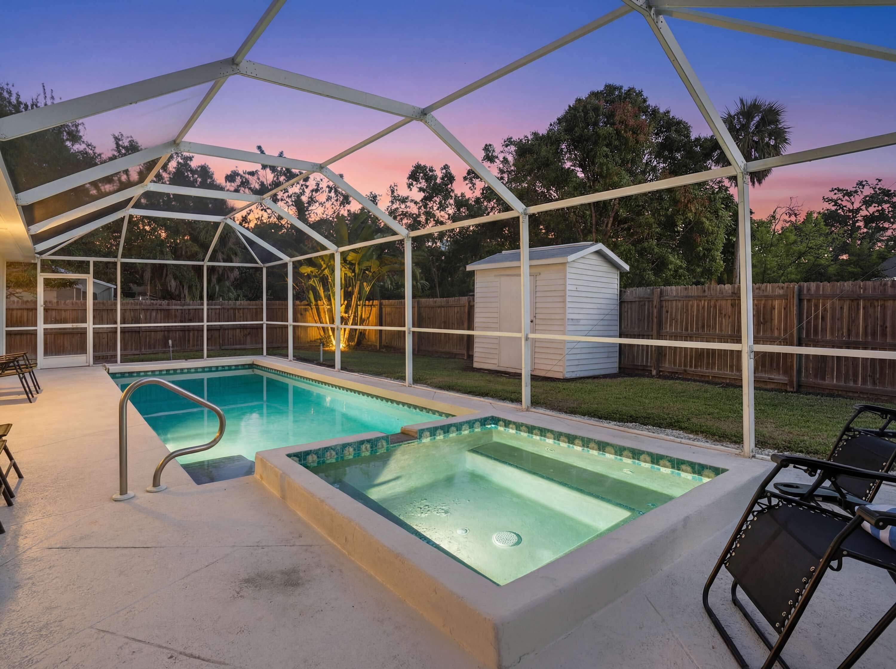 A covered backyard with a swimming pool, a hot tub, and a small shed.