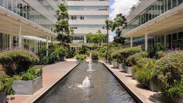 A modern building with a central water feature and surrounding greenery. - Magnifico Nuevo Departamento a Pasos de Polanco (Ciudad de México)